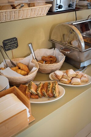 A buffet with various baked goods, including croissants and pastries, arranged on a counter. - Finiki Plaza (Pylos-Nestoras)