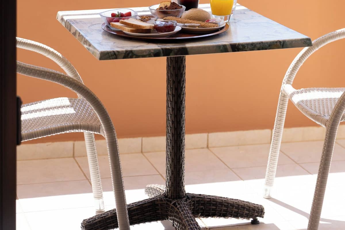 A table with breakfast items and drinks, overlooking a scenic view.