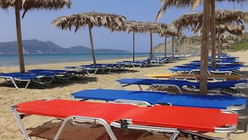 Κοντά στην παραλία, ξαπλώστρες (σεζλόνγκ), ομπρέλες θαλάσσης, beach bar