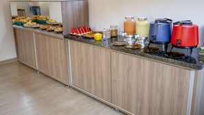 Una encimera de cocina con diversos alimentos y dispensadores de bebidas.