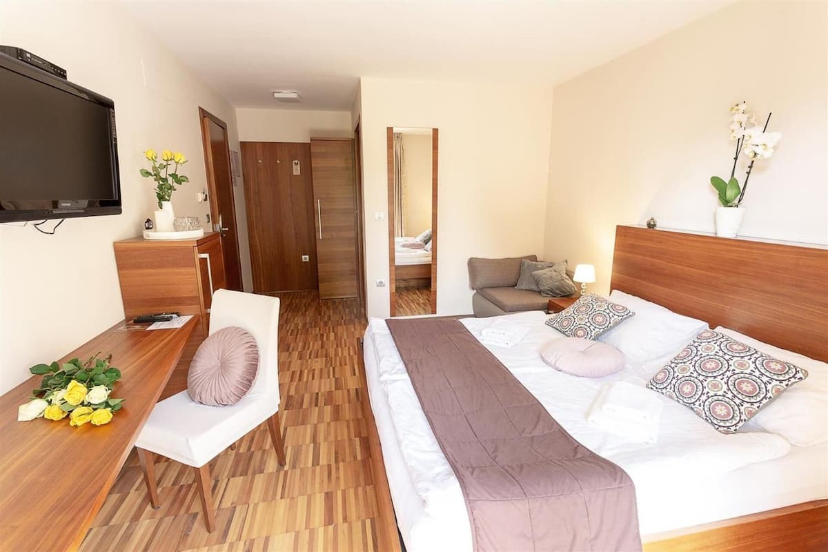 Une chambre d’hôtel avec un lit, une table de chevet, une télévision et une vue sur le couloir.