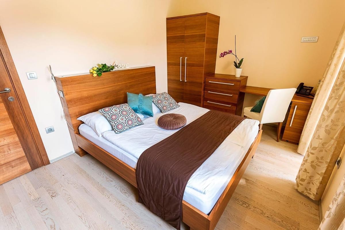 Une chambre à coucher avec un lit en bois, une armoire, un bureau et une chaise.