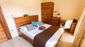 Un dormitorio con una cama de madera, un armario, un escritorio y una silla.