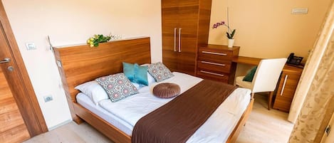 Un dormitorio con una cama de madera, un armario, un escritorio y una silla.