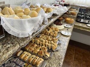 Un buffet con diversi prodotti da forno, tra cui panini, dolci e torte.