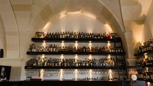 A bar with multiple shelves of liquor bottles and glasses. - Masseria Bagnara (Lizzano)