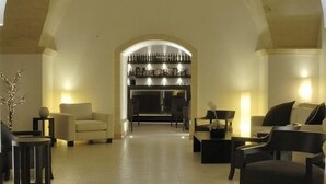 A spacious lobby with a high arched ceiling, a fireplace, and modern seating arrangements. - Masseria Bagnara (Lizzano)