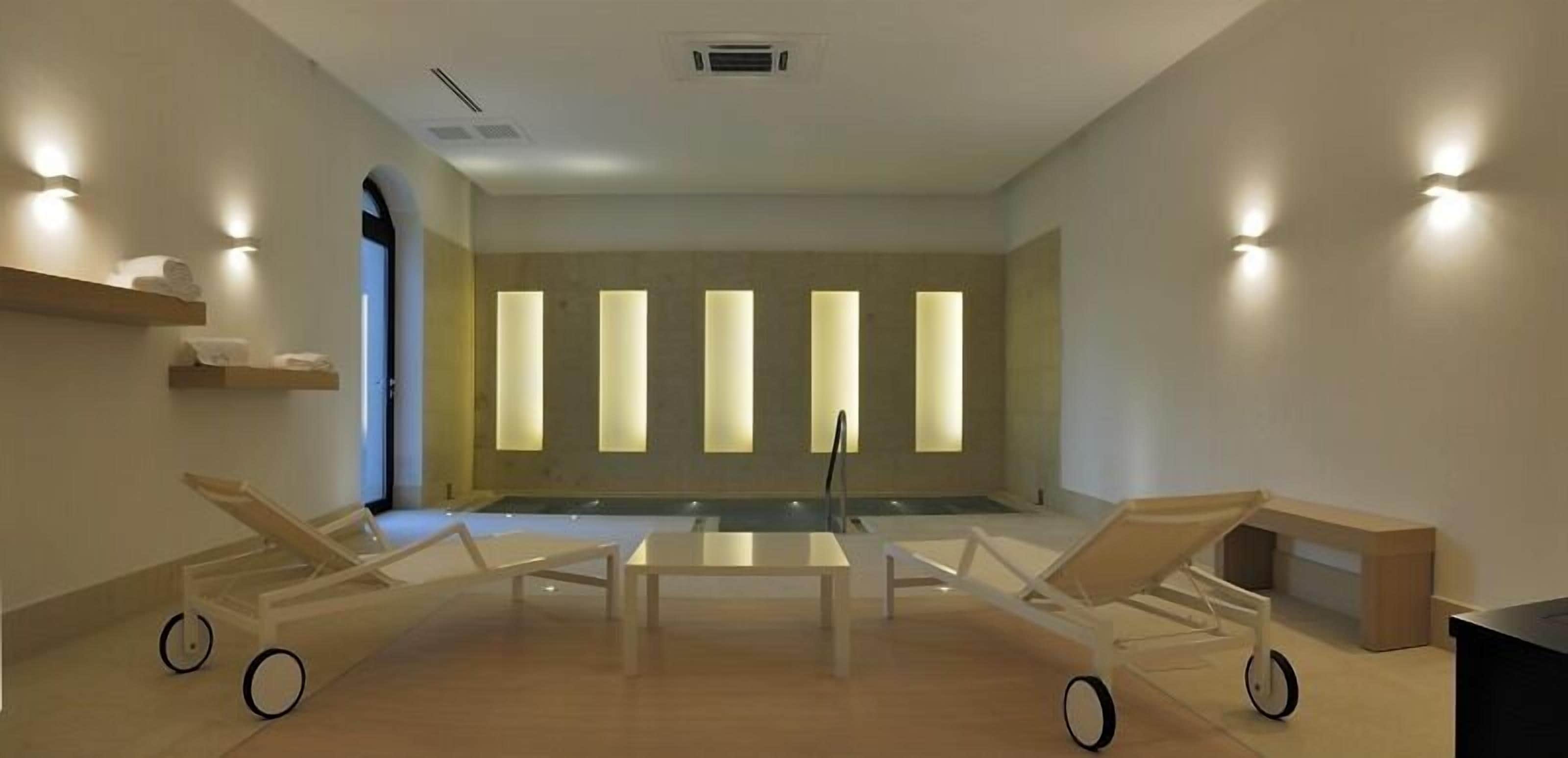 A modern room with a large window, a central table, and two lounge chairs.
