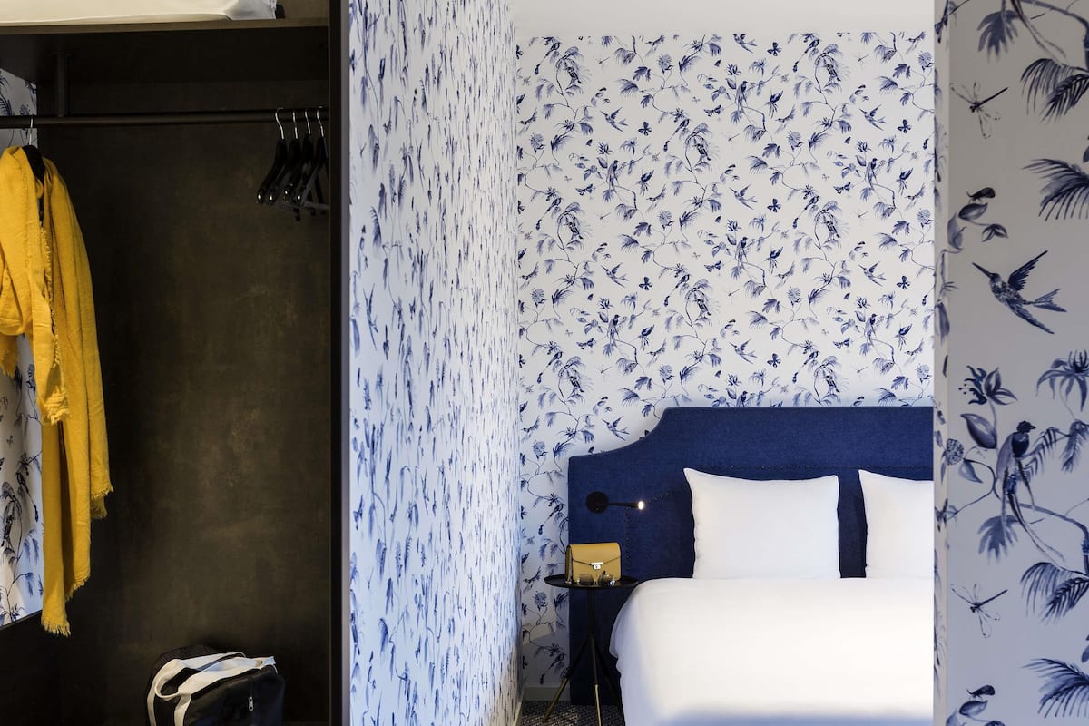 Une chambre d’hôtel avec un lit, une armoire et une table de chevet.