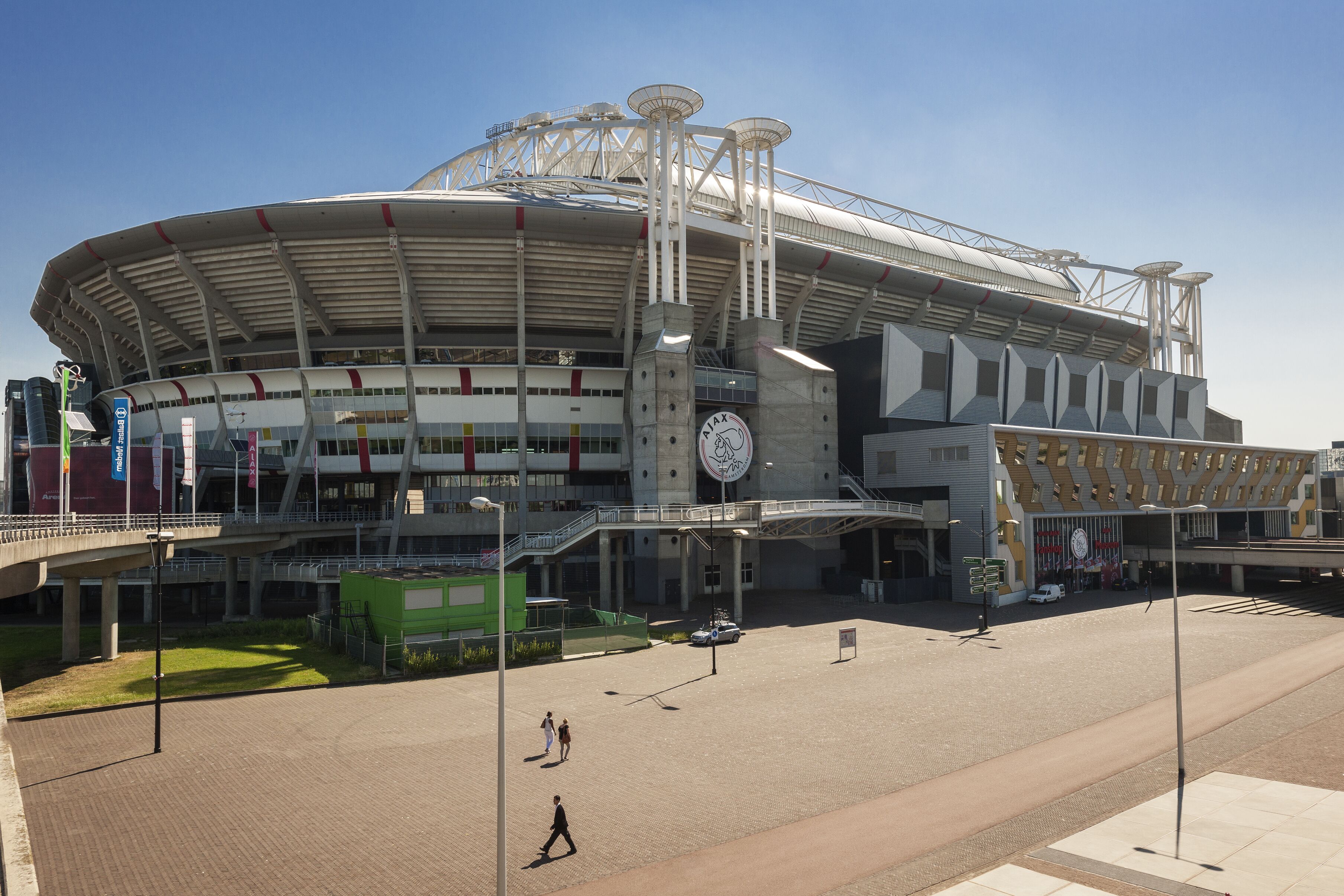 Un estadio grande con una estructura de techo distintiva y una torre del reloj central.