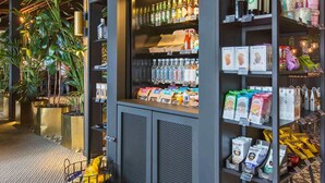 Een winkel met schappen vol ingeboute dranken, verpakte snacks en een presentatie van vers fruit.