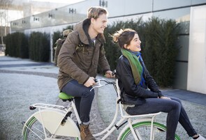 Dos personas andando en bicicleta blanca con detalles verdes.
