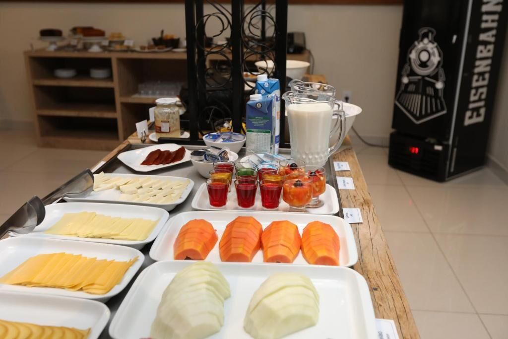 A buffet table with various food items and a milk jug.