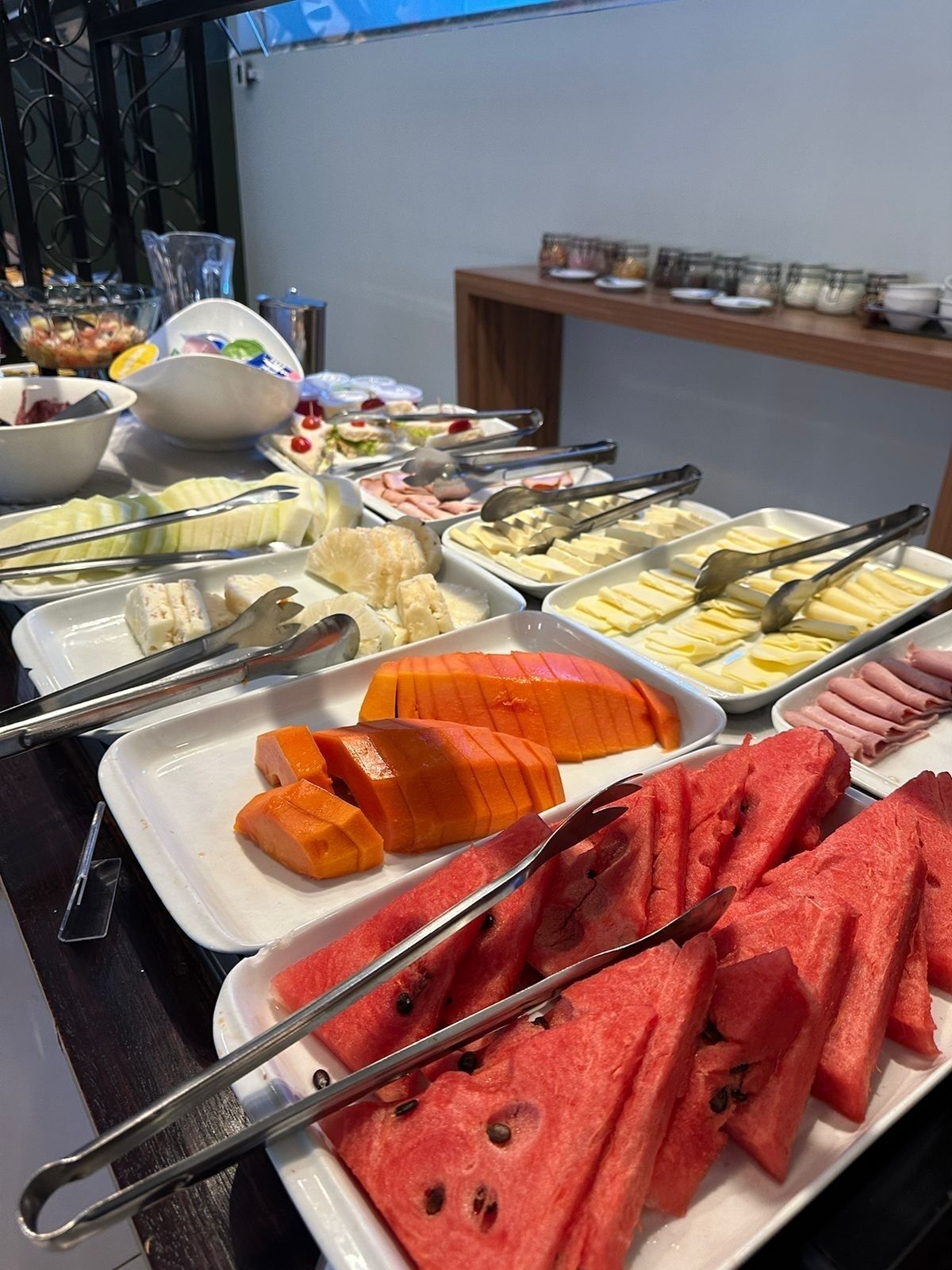 En buffet med forskellige retter, herunder vandmelon, ost og andre tilrettelagte serveringer.