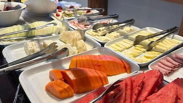 En buffet med forskellige retter, herunder vandmelon, ost og andre tilrettelagte serveringer.