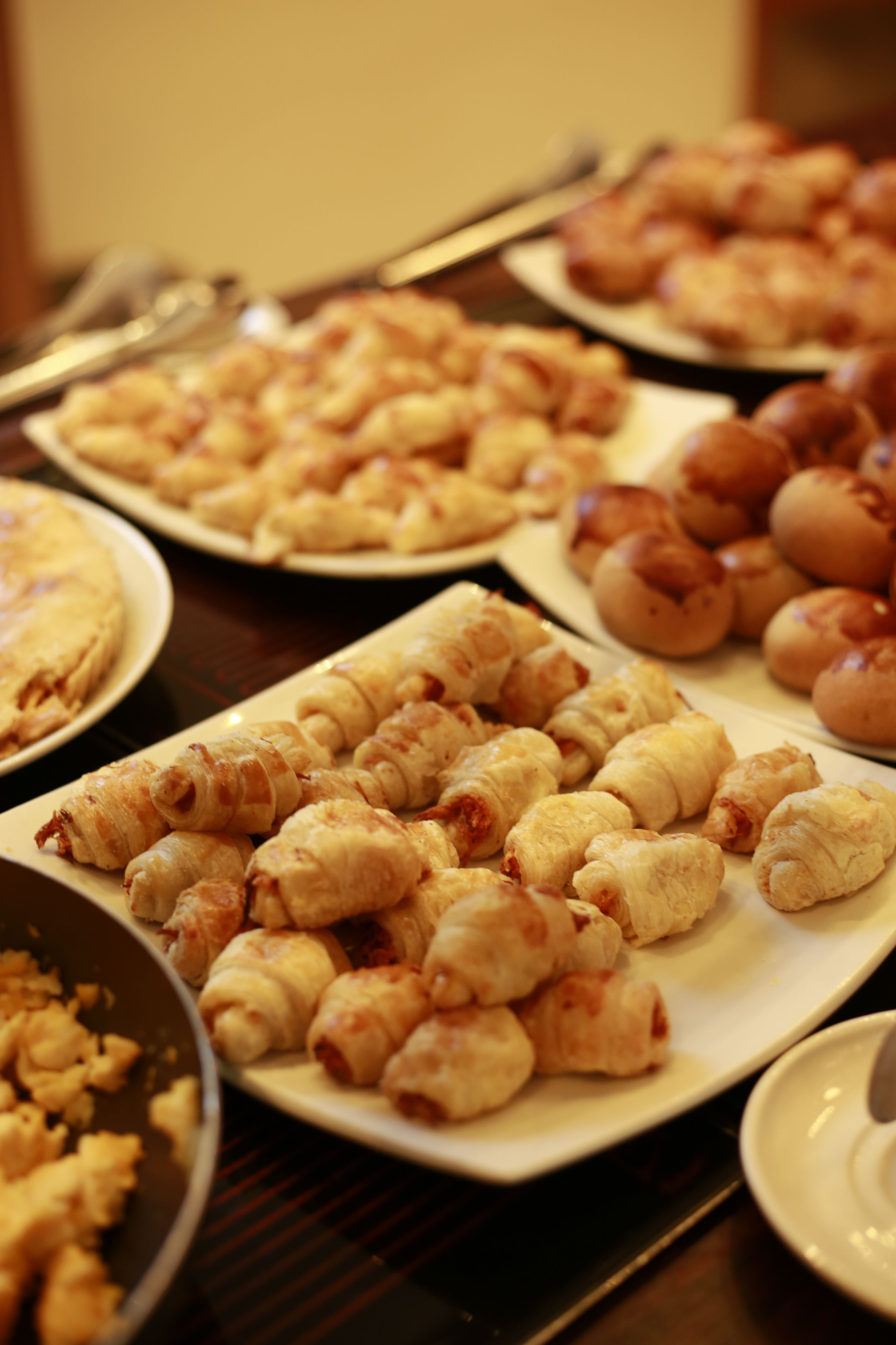 A table with various food items, including pastries and bread.