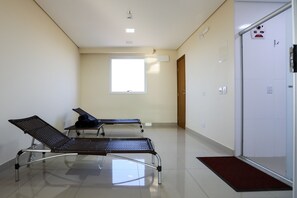 A hospital room with two reclining chairs, a window, and a door. - Hotel Amsterdam Montes Claros (Montes Claros)