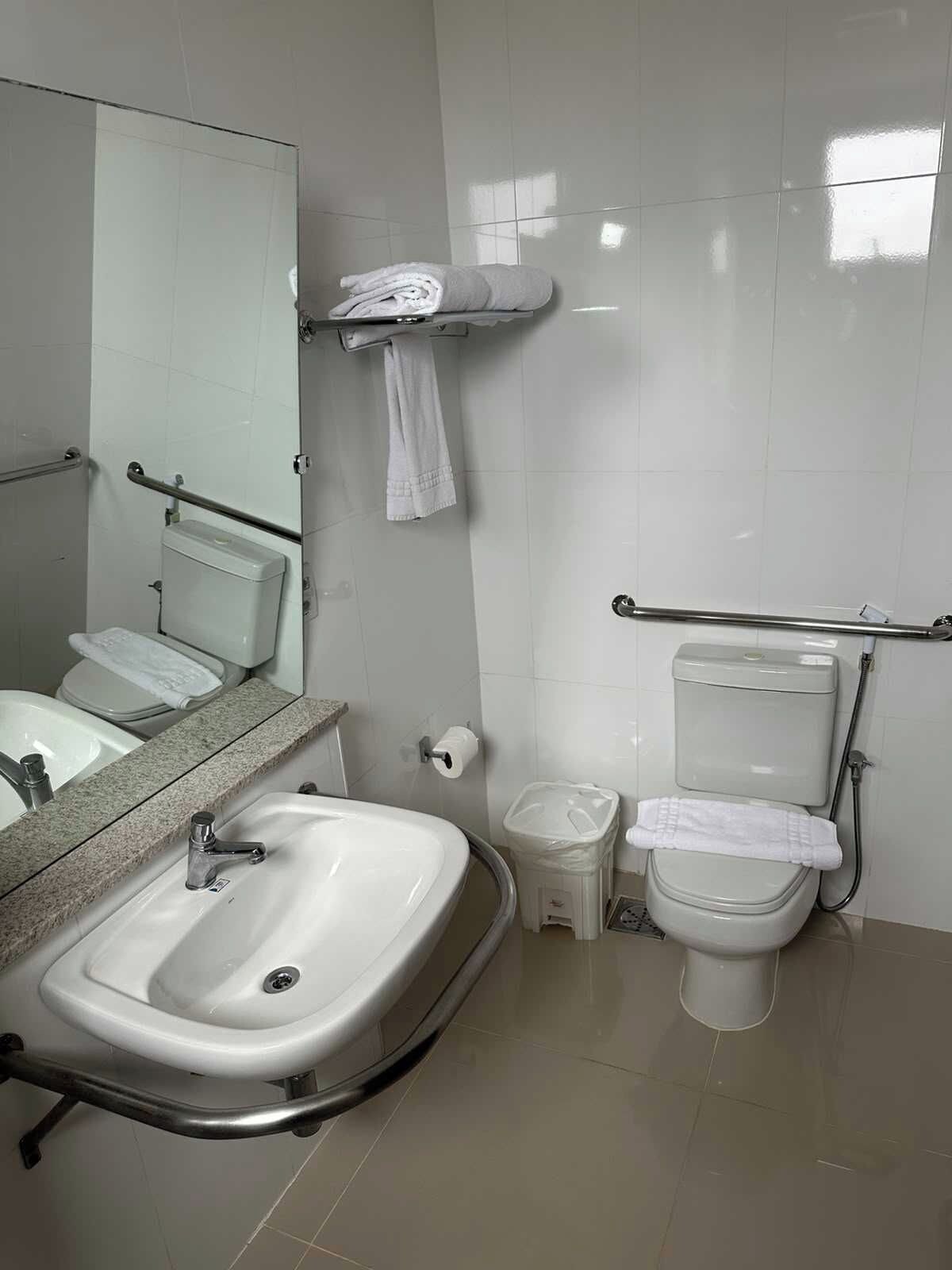 Une salle de bain avec un lavabo, des toilettes et un miroir.
