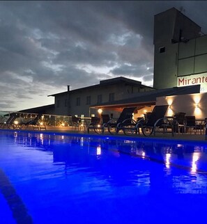 A swimming pool with lounge chairs and a building with a sign reading "Mirante". - Hotel Mirante São Brás (Sao Bras do Suacui)