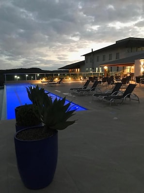 A poolside area with lounge chairs and a building in the background. - Hotel Mirante São Brás (Sao Bras do Suacui)