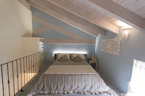 A bedroom with a large bed, a nightstand, a dresser, and a decorative wall piece. - Palascia Wellness Relais (Otranto)