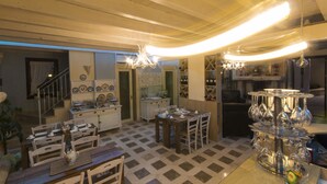 A spacious dining area with a checkered floor, wooden furniture, and a wine rack. - Palascia Wellness Relais (Otranto)
