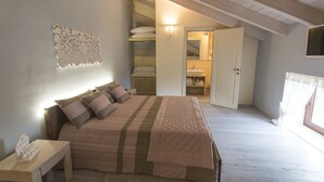 A bedroom with a bed, bedside table, and a wall-mounted light fixture. - Palascia Wellness Relais (Otranto)