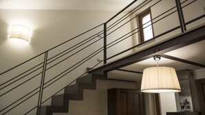 Una escalera con barandales metálicos y una puerta de madera en la parte superior.