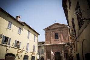 Una calle estrecha con edificios de arquitectura tradicional, incluyendo una iglesia con una fachada destacada y ventanas arqueadas.