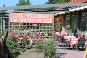 A cafe with outdoor seating and a sign indicating it is a restaurant and bar. - Berghotel Zum Zirm (Renon)