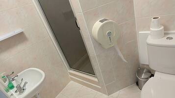Un baño con lavamanos, inodoro y ducha.