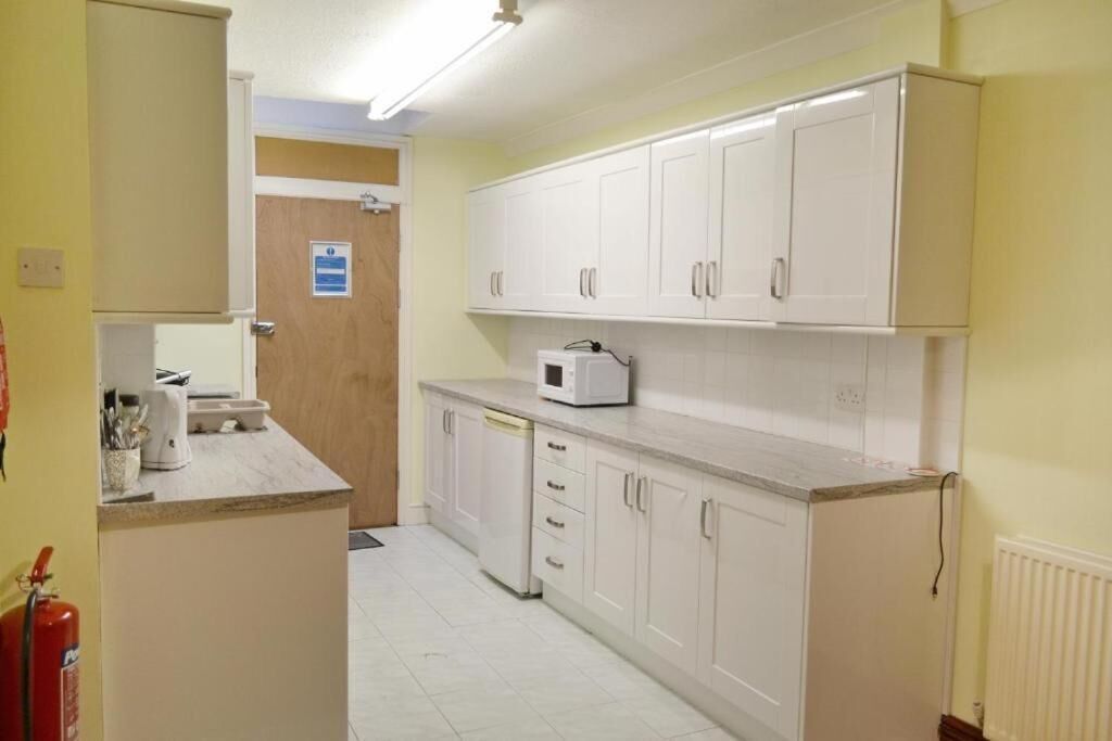 A kitchen with white cabinets, a microwave, and a dishwasher.
