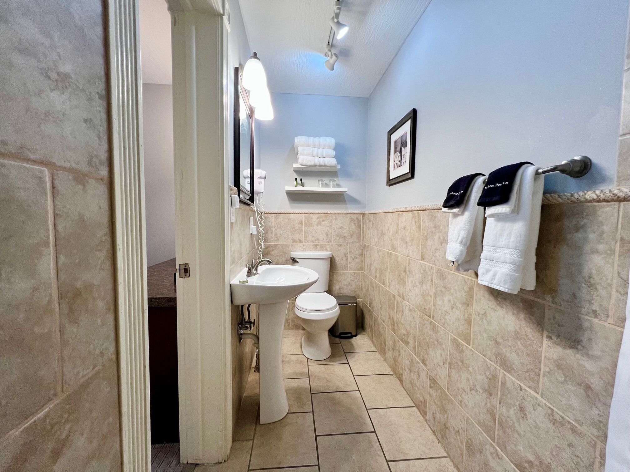 A bathroom with a sink, toilet, and towel rack.