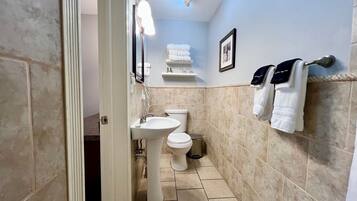 A bathroom with a sink, toilet, and towel rack.