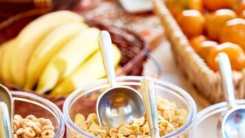 A buffet with various food items including fruits, cereals, and other snacks.