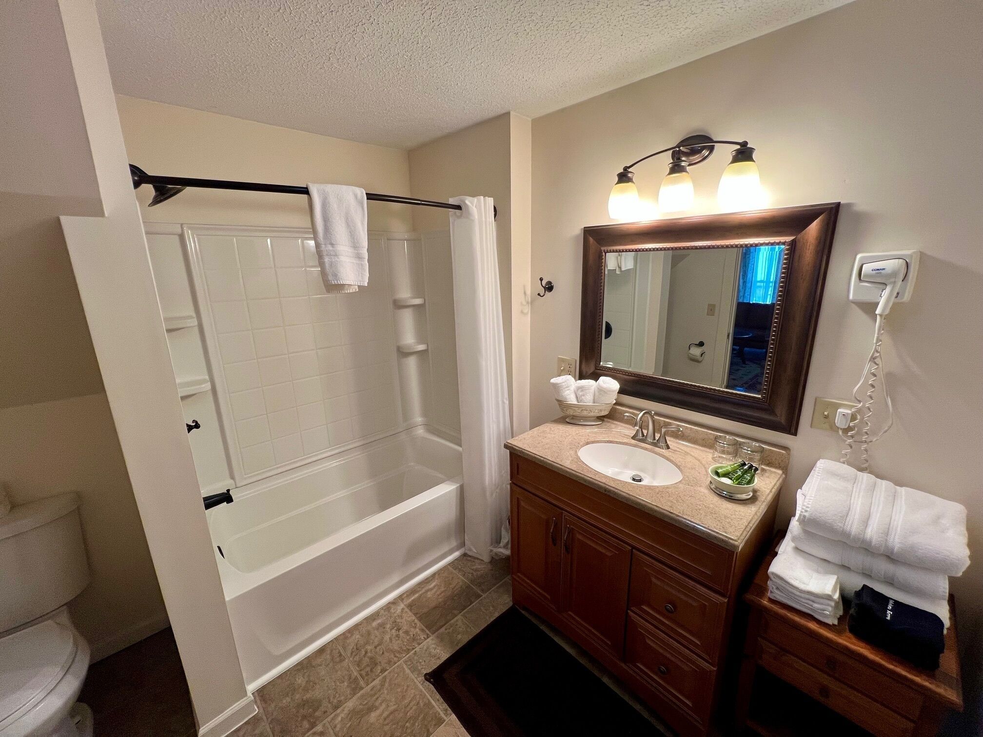A bathroom with a bathtub, a sink, a mirror, and a towel rack.