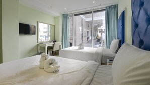 A hotel room with two beds, a desk, a television, and a large window with curtains. - Lion King Hotel (Kaohsiung)