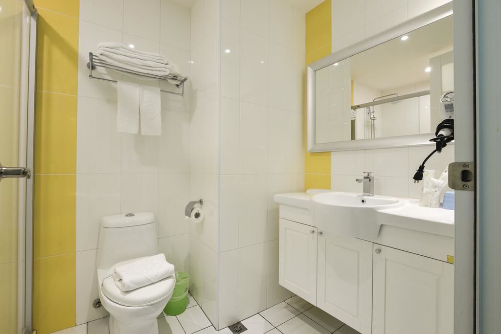A modern bathroom with a toilet, sink, and mirror.