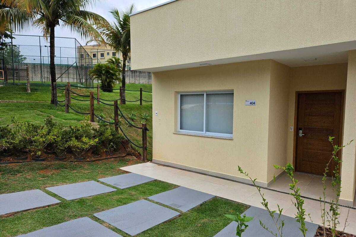 Un edificio moderno con fachada color beige, un letrero con el número 404 y una puerta de madera.