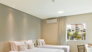 Una habitación de hotel con dos camas, un escritorio y una silla.