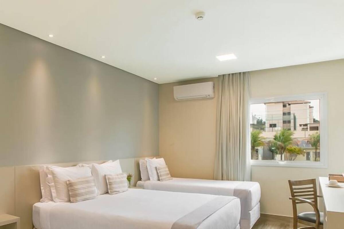 Una habitación de hotel con dos camas, un escritorio y una silla.