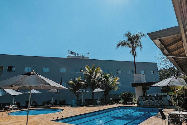 Una piscina al aire libre, sombrillas, tumbonas