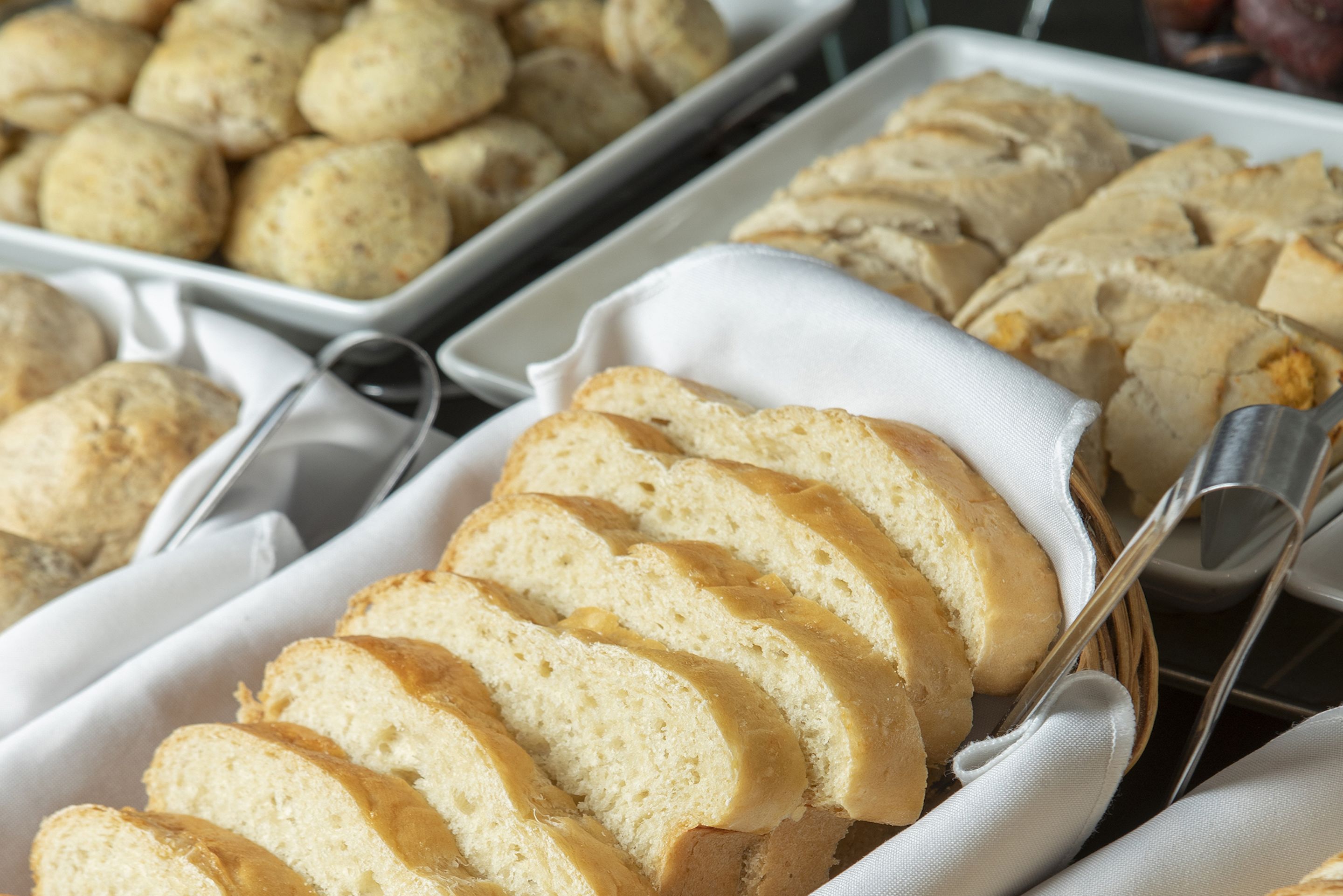 A tray of sliced bread with a knife and a cloth napkin.