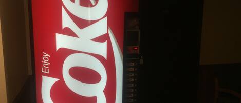 A vending machine with a prominent Coca-Cola logo and the word "Enjoy" on it.