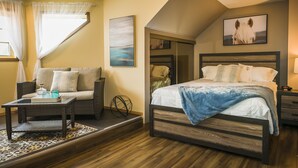 Un dormitorio con cama, sofá, una mesita de noche con artículos de aseo y un espejo.
