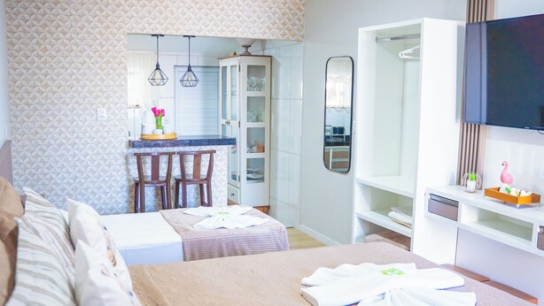 A hotel room with a bed, a desk, and a TV. - Pousada Paraíso Tropical (Penha)