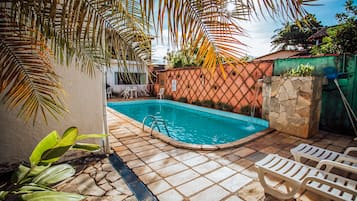 Alberca al aire libre, sombrillas en la alberca y camastros