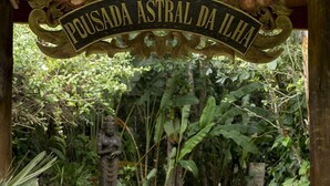 Een pad van stenen dat naar een bord met de tekst 'Pousada Astral da Ilha' leidt.