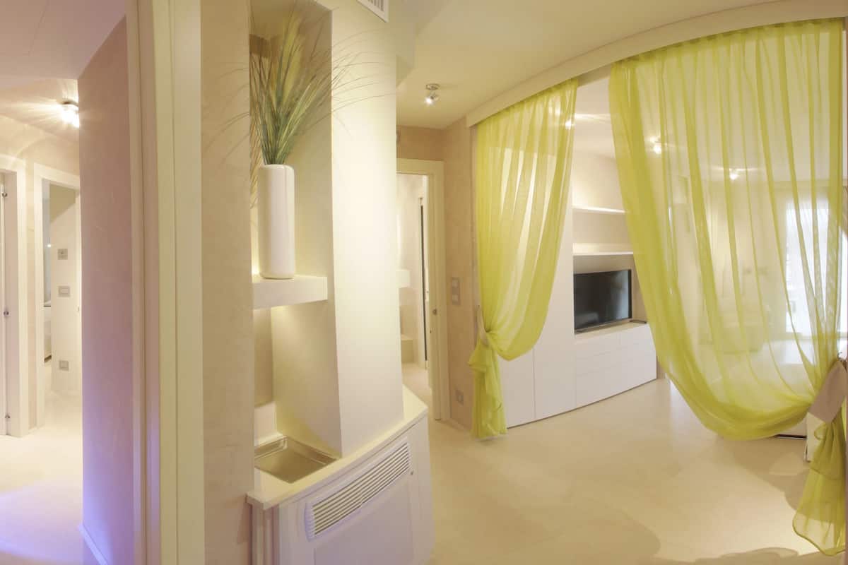 Une chambre d’hôtel moderne dotée d’un dressing, d’un grand miroir et d’une télévision.