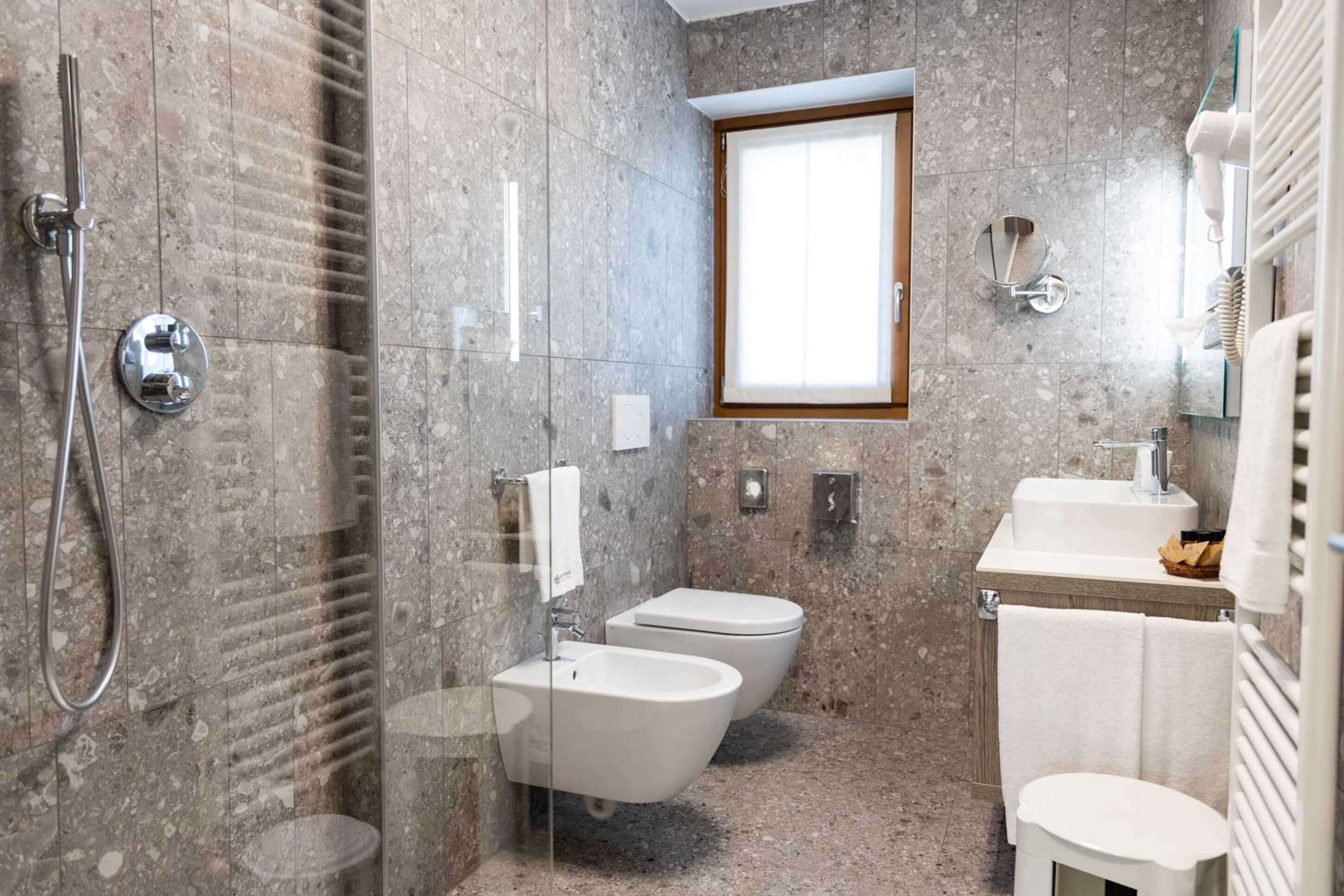 Une salle de bain moderne équipée d’une douche, d’un bidet, de toilettes et d’un lavabo.
